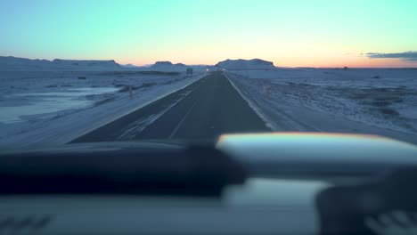 Driving-on-icy-roads-in-Iceland-in-the-winter-towards-the-sunrise-in-February