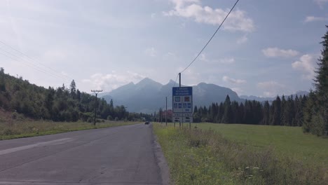 Die-Straße,-Die-Die-Polnische-slowakische-Grenze-In-Tatry-An-Einem-Hellen-Sonnigen-Tag-Mit-Bergen-Und-Wald-Im-Hintergrund-überquert---Breite-Aufnahme