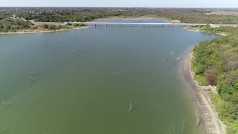 Aerial-video-of-Lake-Lavon-on-the-North-West-side-with-trees-in-the-water-approaching-a-bridge