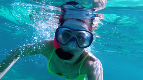 Young-woman-snorkeling-near-surface-in-crystal-clear-water-of-Mediterranean