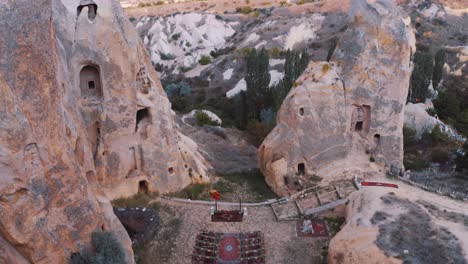 Drone-flies-between-two-volcanic-peaks-and-caves-revealing-the-spectacular-landscape-of-Cappadocia,-Uchisar,-near-Goreme,-Turkey