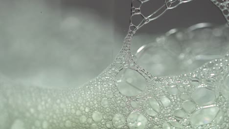 Macro-soap-bubbles-extreme-close-up-with-a-shorter-light-sweep-across-frame