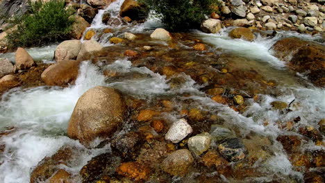 video-of-fresh-water-running-downstream,-through-large-and-small-rocks