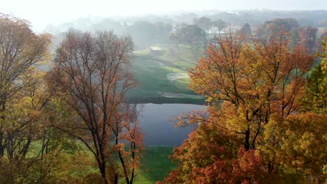 Cinematic-aerial-reveal-of-Lancaster-Country-Club,-Conestoga-River,-golf-course-greens,-foggy-autumn-sunrise
