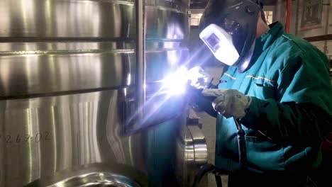Worker-welding-stainless-steel-tank,-using-TIG,-MIG-welder,-close-up,-dolly,-slide,-movement