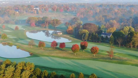Lancaster-Country-Club-aerial-in-autumn-morning,-reflections-of-colorful-fall-leaves-and-trees-in-water