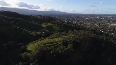 Flying-over-green-hills-and-trees-in-San-Jose,-CA