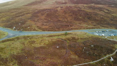 Aerial-shot-of-car-driving-through-mountains-in-Ireland
