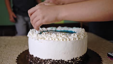 A-young-girl-sticks-a-number-candle-into-a-white-cake