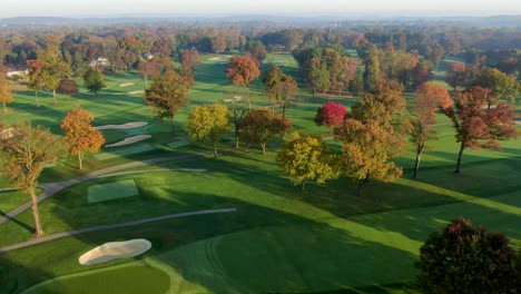 Cinematic-aerial-pan-of-country-club-golf-course-in-Lancaster-PA-in-autumn-colorful-leaves,-fairways,-river