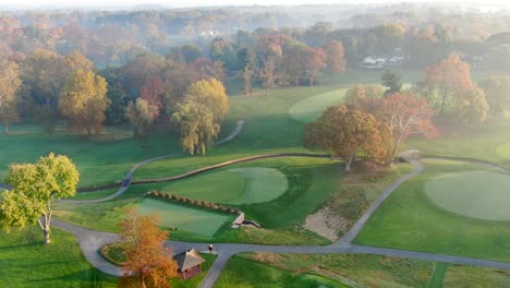 Aerial-features-rolling-hills-of-country-club-golf-course-in-autumn,-Lancaster-Pennsylvania
