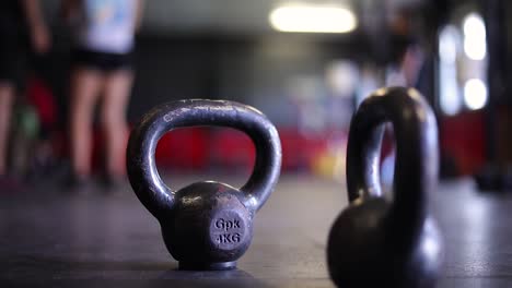 Two-Four-Kilogram-Kettle-Weights-with-handles-on-the-floor-of-an-indoor-Crossfit-Gym