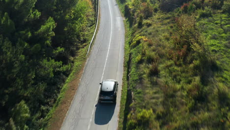 Vehicle-driving-through-the-green-late-summer-colors-of-the-Croatian-countryside-as-the-fall-colors-start-to-change