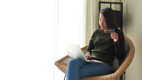Junge-Asiatische-Frau,-Die-Ihre-Kreditkartendetails-In-Einen-Laptop-Eingibt