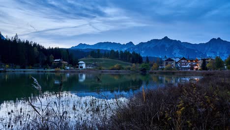 Abendlicher-Zeitraffer-Von-Seefeld-In-Tirol-Mit-Blick-über-Den-Wildsee-Auf-Die-Stadt-Und-Die-Berge-Der-Alpen