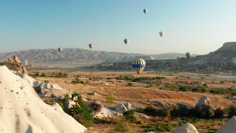 Hot-air-balloons-flying-over-the-fairy-chimneys-of-Goreme-Cappadocia,-Turkey