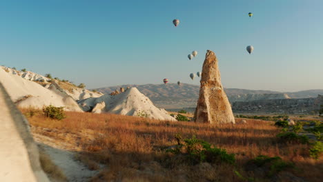 Dolly-in-shot-of-hot-air-balloons-flying-over-Goreme-Cappadocia,-Turkey