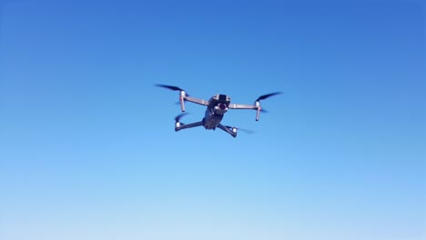 A-drone-hovers-in-front-of-a-beautiful-blue-sky