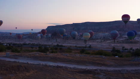 Dolly-in-aerial-shot-of-the-hot-air-ballons-at-Goreme-Cappadocia-late-evening