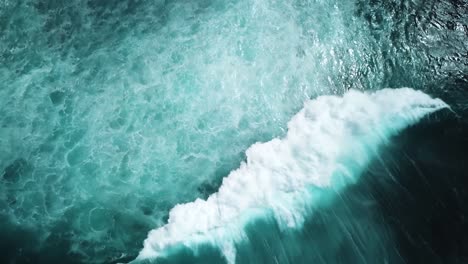 Dark-Aerial-shot-of-a-huge-powerful-wave-crashing-on-the-choppy-ocean-waters