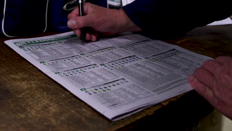 Placing-or-marking-bets-on-a-racing-guide-newspaper