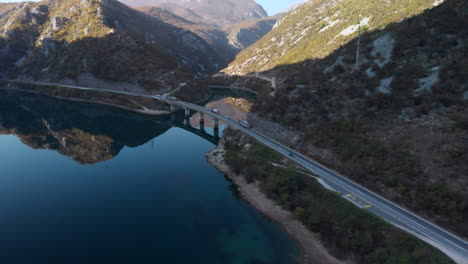Scenic-road-highway-bridge-through-Bosnian-mountains,-The-Neretva-River,-aerial