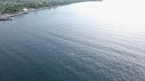 aerial-drone-shot-over-the-beach-and-fly-close-over-the-traditional-boat-in-Bali,-Indonesia