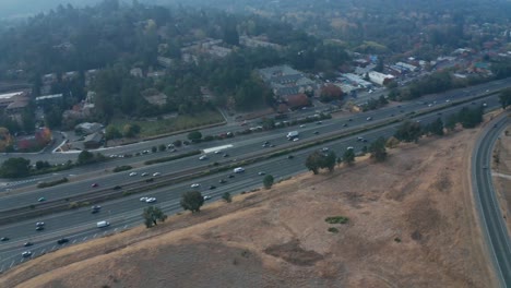 Heavy-traffic-on-the-highway-near-hills-and-smoke-from-wildfires