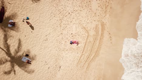 Aufsteigende-Luftaufnahme-über-Einer-Frau-In-Einem-Roten-Bikini,-Die-Sich-An-Einem-Tropischen-Sandstrand-In-Hawaii-Entspannt