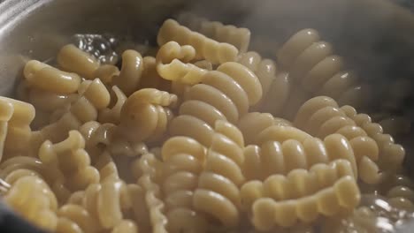 Close-up-of-large-saucepan-of-Radiatore-pasta-cooking