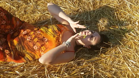 Young-brunette-girl-lying-down-in-a-wheat-field-at-the-beginning-of-summer-while-singing