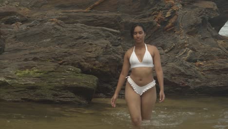 Epic-slowmotion-of-a-girl-in-a-white-thong-bikini-walking-out-of-a-river-with-a-rockledge-in-the-background