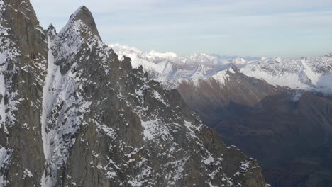 Panoramasicht-In-Zeitlupe-Vom-Gipfel-Der-Wintersaison-Ab-Den-Alpen,-Schneebedeckte-Gipfel-Im-Hintergrund