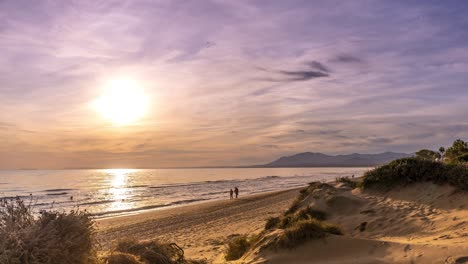 fast-time-lapse-Marbella-Beach-sunset-with-people-walking-across-the-beach-as-the-sun-sets,-4k-timelapse