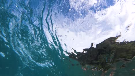 Einzigartige-Unterwasserperspektive-Unter-Einer-Shorebreak-Welle,-Die-Auf-Das-Ufer-Trifft
