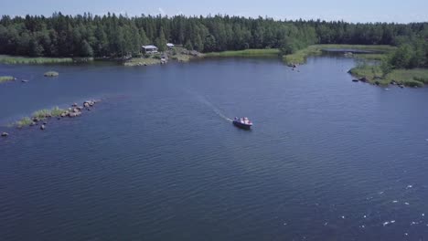 Boating-family-cruising-through-summer-archipelago-in-Finland,-aerial