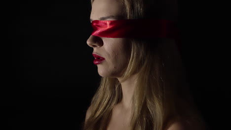 Portrait-of-the-young-woman-blindfold-with-red-ribbon