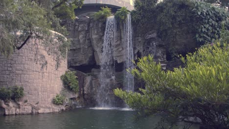 Wasserfall-In-Der-Nähe-Eines-Kleinen-Sees-In-Einem-Park-Während-Des-Tages