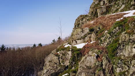 Drone-flight-close-to-a-stony-hilltop-in-winter
