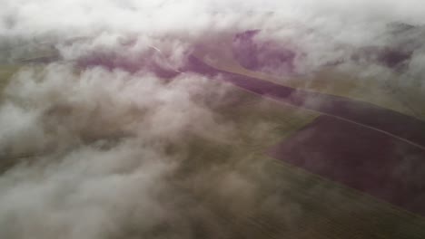 Tomas-Aéreas-Sobre-La-Niebla-Matutina-Con-Vistas-A-Un-Par-De-Aerogeneradores