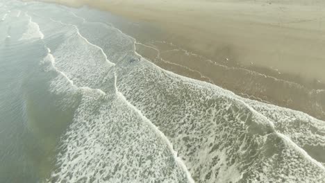 Fast-aerial-shot-of-a-beach-in-Domburg-with-people-surfing