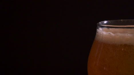 Ausgefallenes-Pint-Craft-Beer-Auf-Einem-Tisch-Mit-Schwarzem-Hintergrund,-Zeitlupen-LKW-Rechts