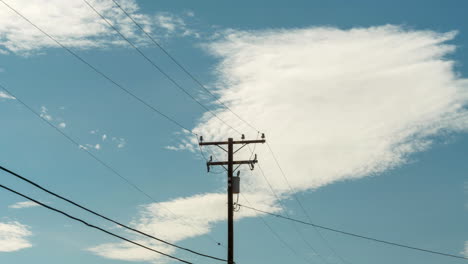 Beautiful-White-Clouds-In-Clear-Blue-Skies-Rolling-Above-Power-Lines---Time-Lapse