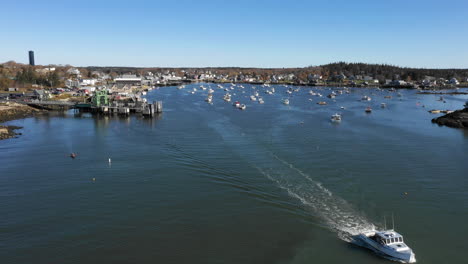 Aerial-Fly-Over-Drone-Footage-showing-boat-leaving-Vinalhaven,-Fox-Islands,-Knox-County,-Maine-USA