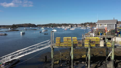 Aerial-Rapid-Fly-Over-Drone-Footage-showing-Lobster-Traps-along-lobster-fishery-ramp-next-to-waters-of-Maine-Coast-at-Vinalhaven,-Fox-Islands,-Knox-Couhty-Maine,-USA