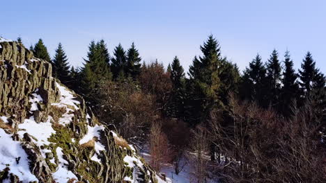Drohnenflug-In-Der-Nähe-Eines-Vulkanischen-Hügels-Im-Winter,-Der-Einen-Natürlichen-Wald-Und-Ein-Schneebedecktes-Plateau-Enthüllt