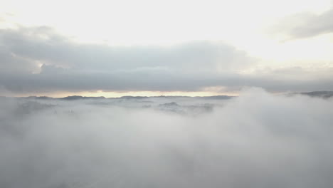 Luftaufnahme,-Drohnenaufnahme,-über-Dichtem-Nebel,-Inmitten-Von-Hügeln-Und-Wäldern,-An-Einem-Nebligen-Herbsttag,-In-Birkeland,-Aust-Agder,-Südnorwegen