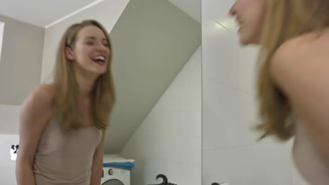 Happy-woman-kissing-mirror-in-her-bathroom