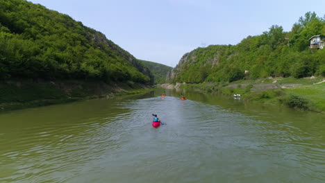 Kayak-aerial-action-shot-as-group-paddles-towards-canyon-in-Kosovo-along-the-Drin-river