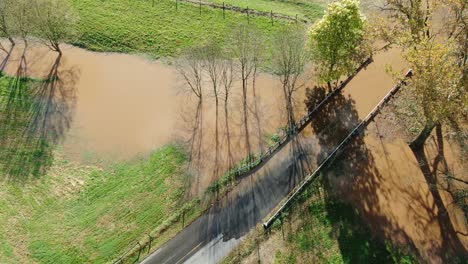 Rising-aerial-of-flood-waters-covering-roadway-in-autumn